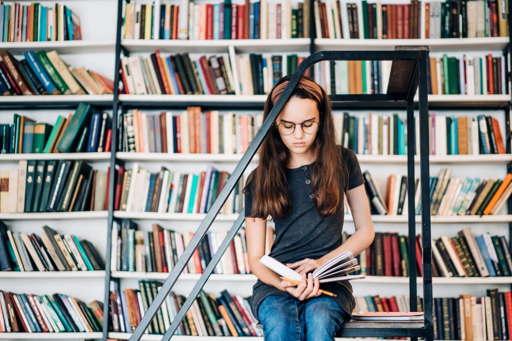 Niña estudiando en la biblioteca